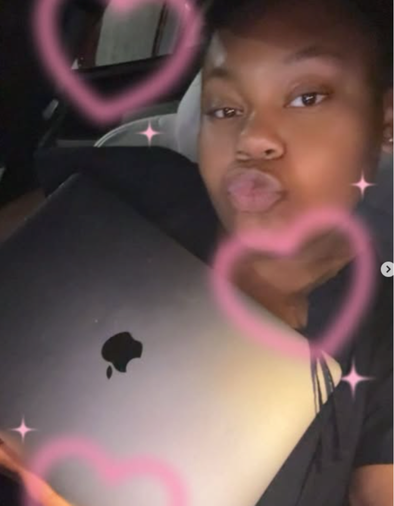 A photo of CS holding a Mac laptop.